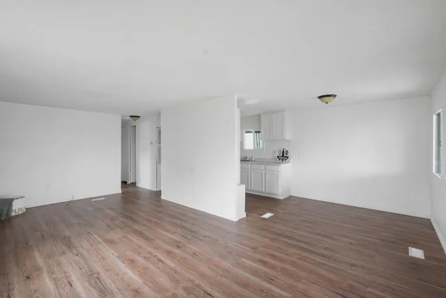 a view of an empty room and wooden floor