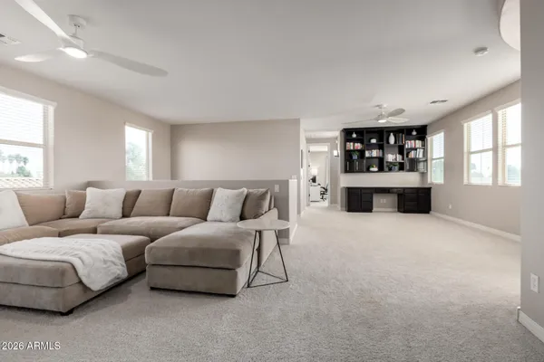 an empty room with a windows and ceiling fan