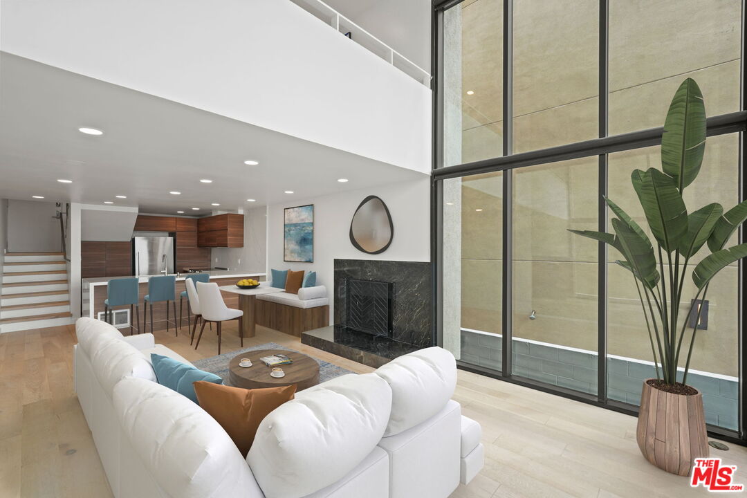 6 Voyage Street, Unit 108 Marina del Rey, CA 90292 - Photo 3 of 27 a living room with furniture a fireplace a rug and a large window