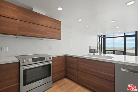 a kitchen with stainless steel appliances wooden cabinets and a stove top oven
