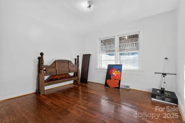 a bedroom with furniture and wooden floor