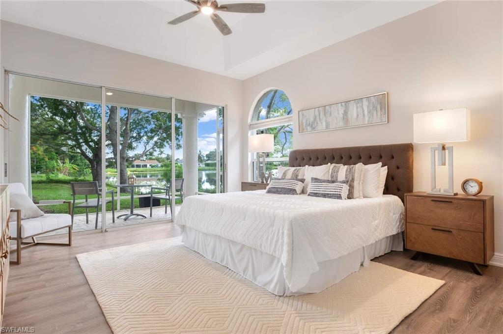 2115 Imperial Golf Course Boulevard Naples, FL 34110 - Photo 13 of 31 a bedroom with a large bed and a lamp on table