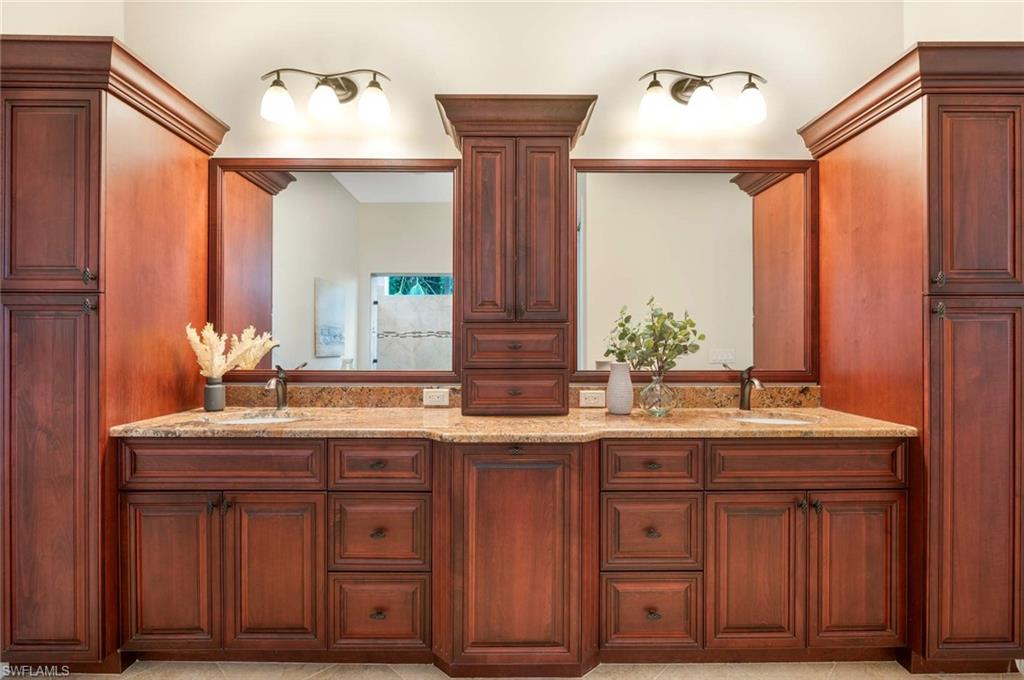 2115 Imperial Golf Course Boulevard Naples, FL 34110 - Photo 14 of 31 a bathroom with a granite countertop sink and a mirror
