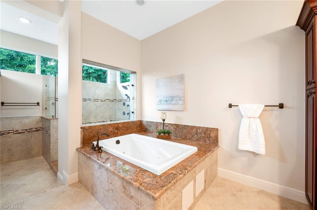 2115 Imperial Golf Course Boulevard Naples, FL 34110 - Photo 15 of 31 a bathroom with a tub sink and mirror