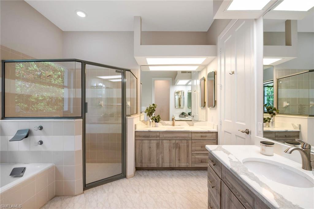2115 Imperial Golf Course Boulevard Naples, FL 34110 - Photo 17 of 31 a bathroom with a tub a sink and mirror