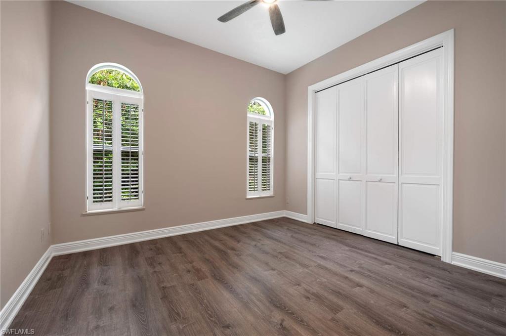 2115 Imperial Golf Course Boulevard Naples, FL 34110 - Photo 18 of 31 a view of an empty room with a window and wooden floor