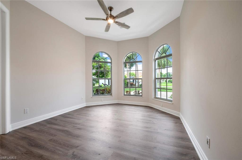 2115 Imperial Golf Course Boulevard Naples, FL 34110 - Photo 19 of 31 a view of an empty room with a window and wooden floor