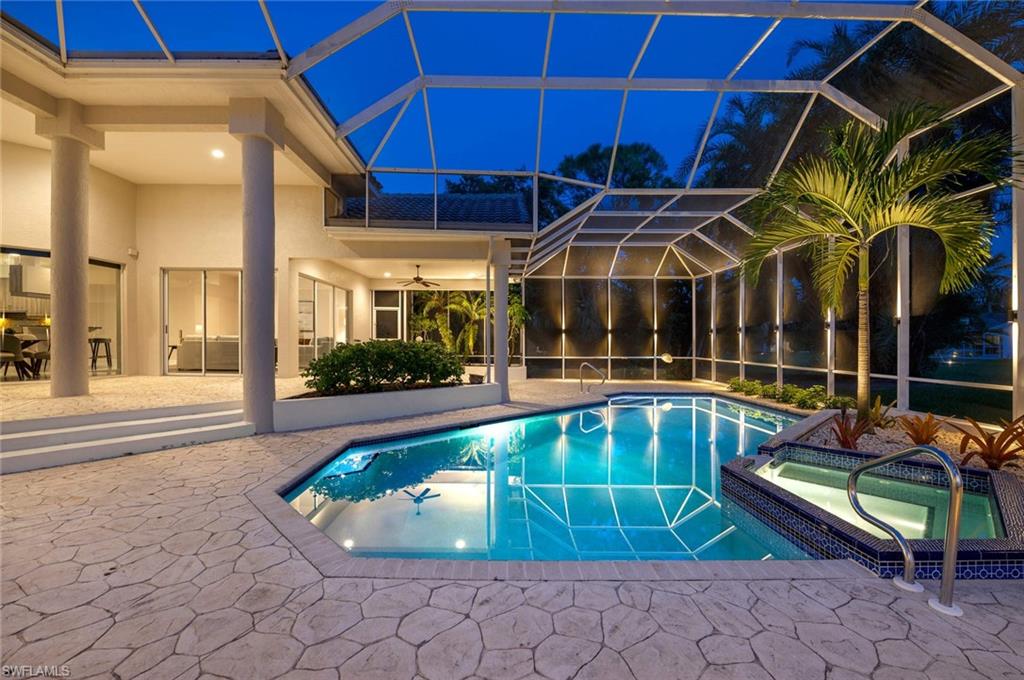 2115 Imperial Golf Course Boulevard Naples, FL 34110 - Photo 29 of 31 a view of a patio with table and chairs under an umbrella