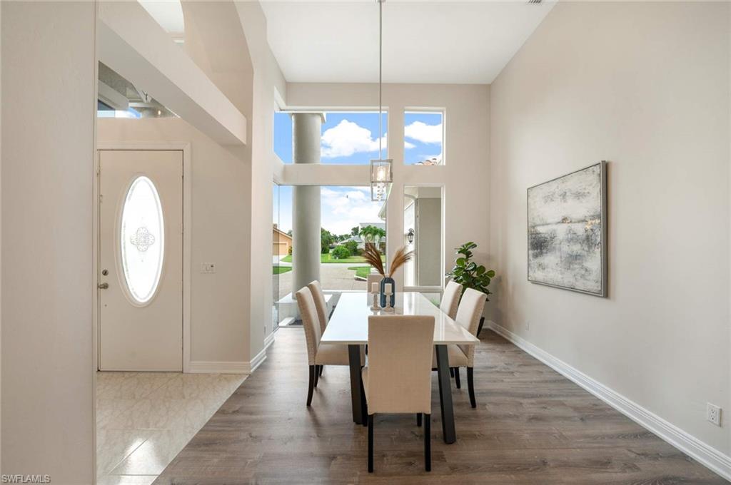 2115 Imperial Golf Course Boulevard Naples, FL 34110 - Photo 7 of 31 a view of a dining room with furniture wooden floor and a chandelier