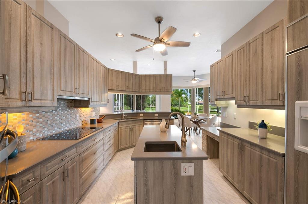2115 Imperial Golf Course Boulevard Naples, FL 34110 - Photo 10 of 31 a kitchen with stainless steel appliances kitchen island granite countertop a sink stove and cabinets