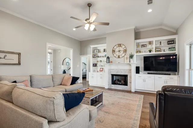 a living room with furniture a flat screen tv and a fireplace