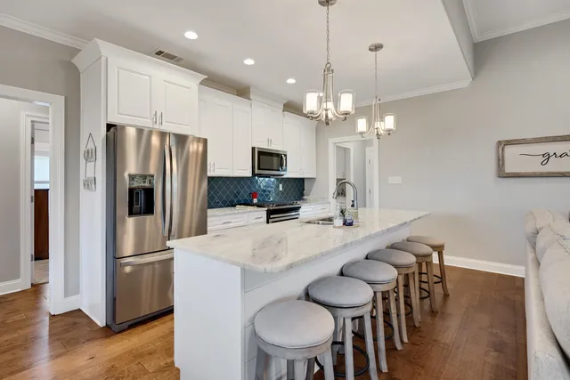 a kitchen with stainless steel appliances a table chairs refrigerator and microwave