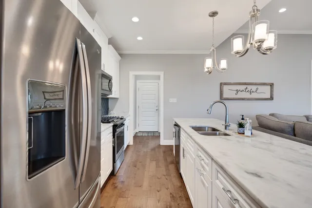 a kitchen with stainless steel appliances granite countertop a sink and a refrigerator