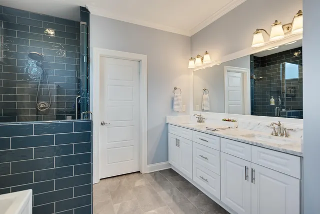 a bathroom with a double vanity sink a large mirror and a shower