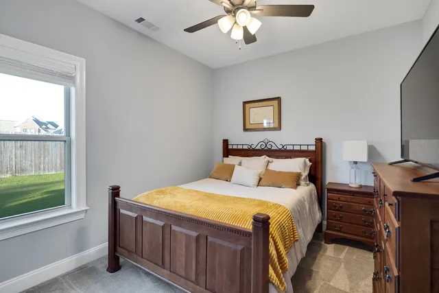 a bed sitting in a bedroom next to a window