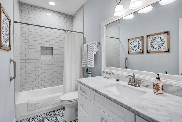 a bathroom with a granite countertop sink toilet and shower