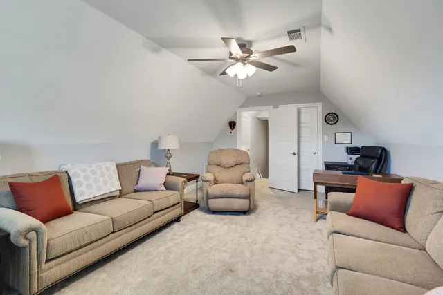 a living room with furniture and a ceiling fan