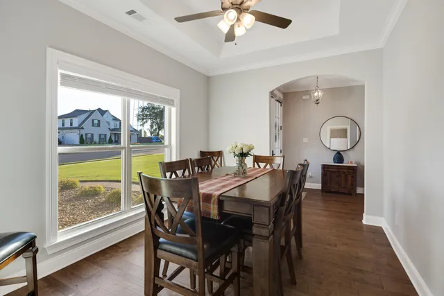 a view of a dining room with furniture a chandelier and wooden floor