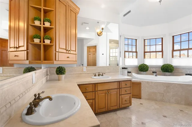 a bathroom with a tub a sink and a window