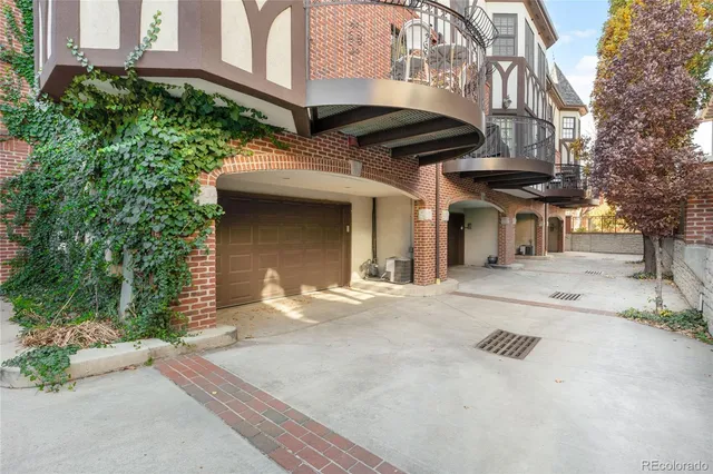 a view of a brick house with large windows and a table and chairs