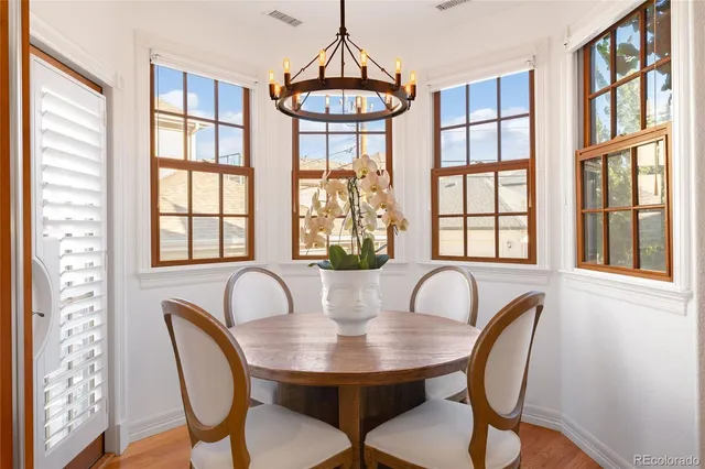 a view of a patio with table and chairs with wooden floor and fence