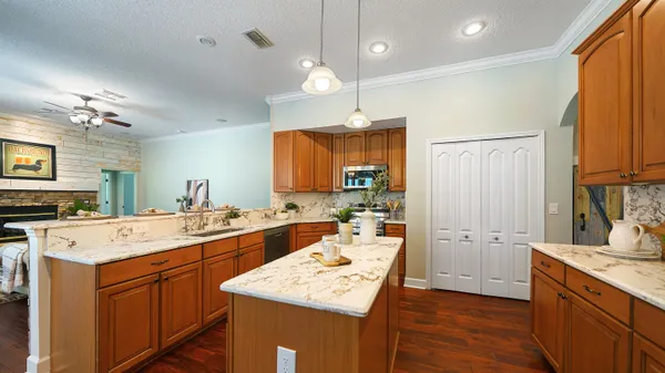 a open kitchen with stainless steel appliances granite countertop a sink a stove and wooden floors