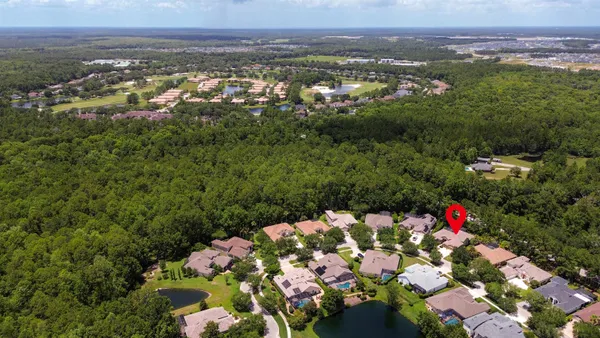 an aerial view of a house with a garden and trees all around