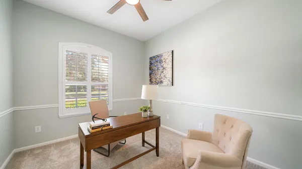 a bedroom with a large bed and a chandelier fan