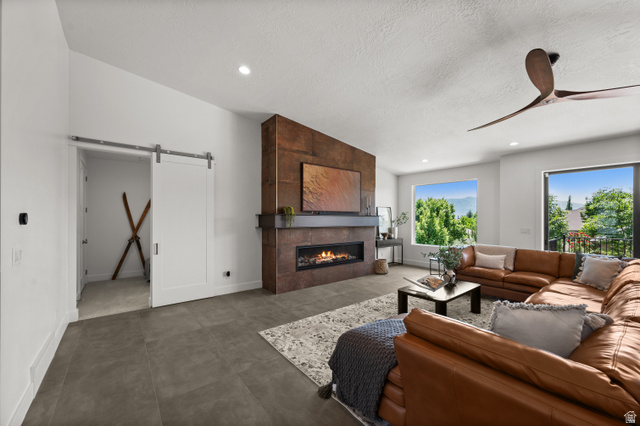 507 West Windmill Gate Cove Draper, UT 84020 - Photo 5 of 46 Living room with a barn door, a fireplace, a ceiling fan, and recessed lighting