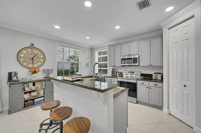 a kitchen with cabinets a stove and a clock