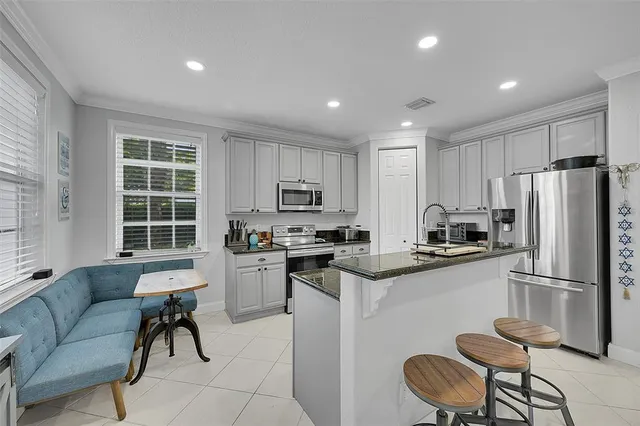 a kitchen with refrigerator a stove and chairs
