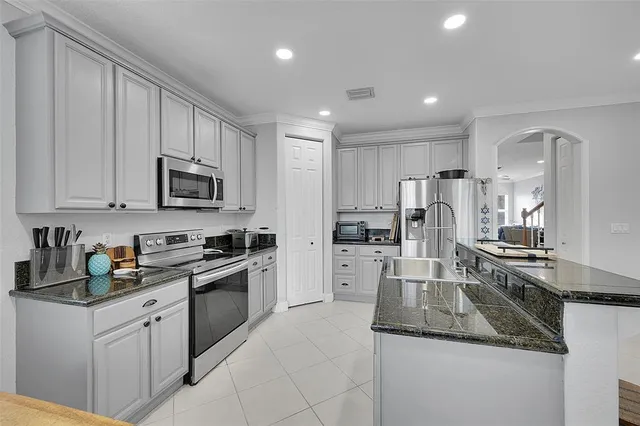 a kitchen with white cabinets and stainless steel appliances