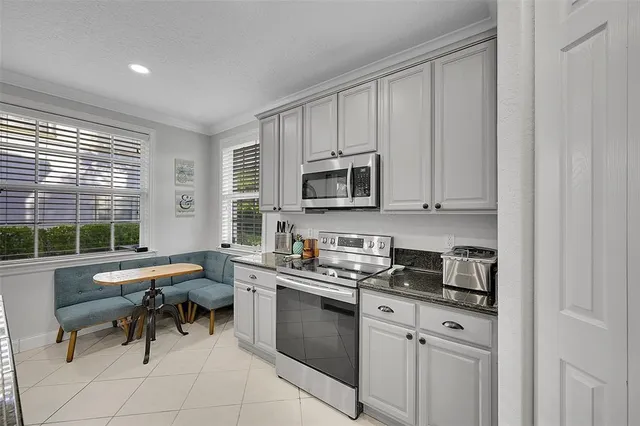 a kitchen with stainless steel appliances granite countertop a stove a sink and a microwave