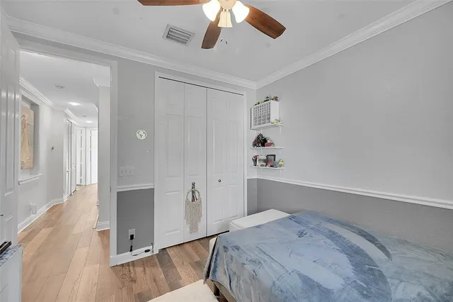 a bedroom with a bed and a chandelier fan