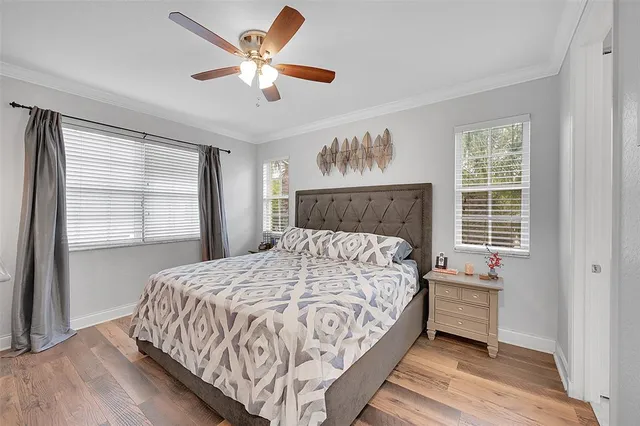 a bedroom with a large bed chandelier and a window
