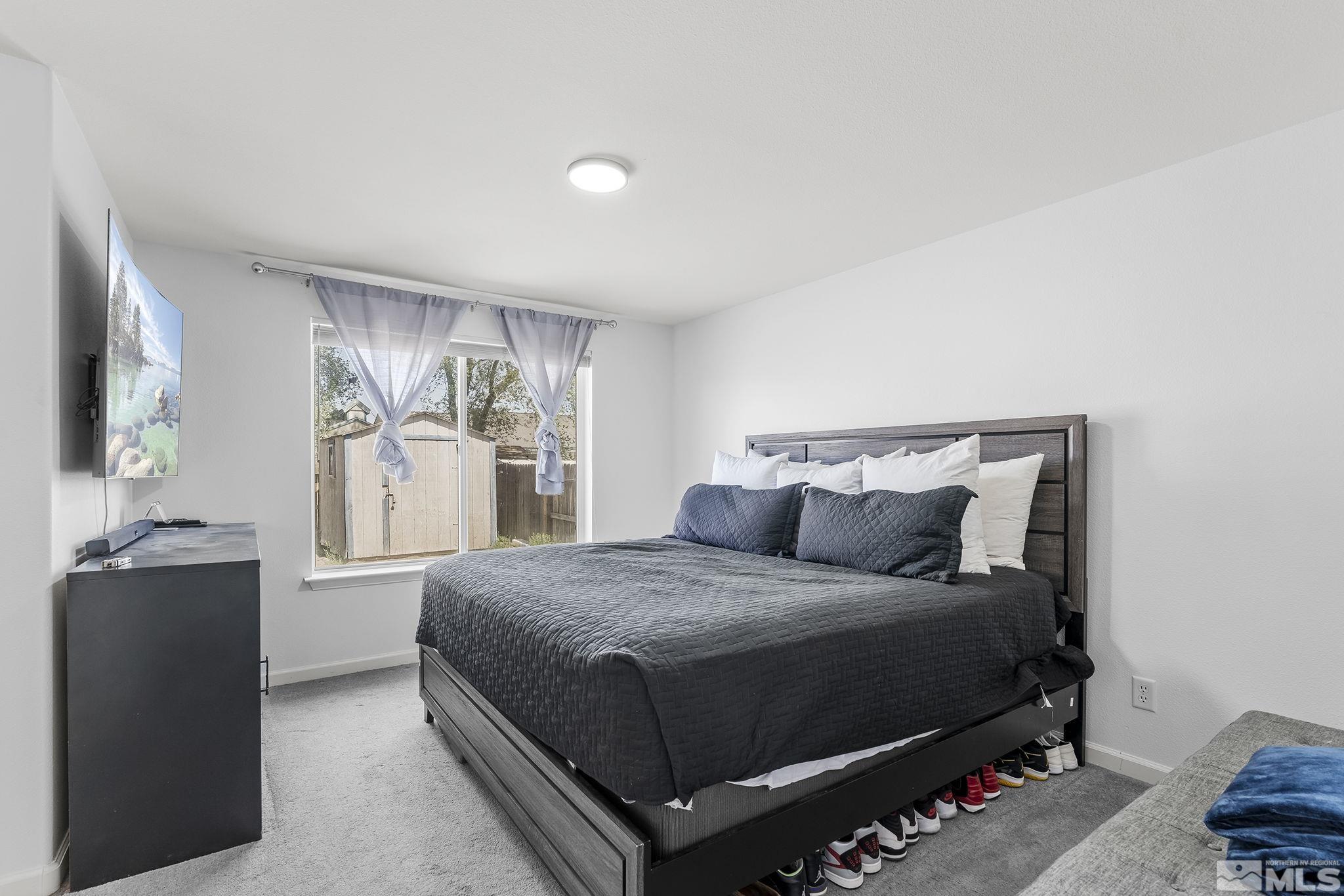 940 Atrium Road Fernley, NV 89408 - Photo 11 of 20 a bedroom with a bed and dresser with mirror