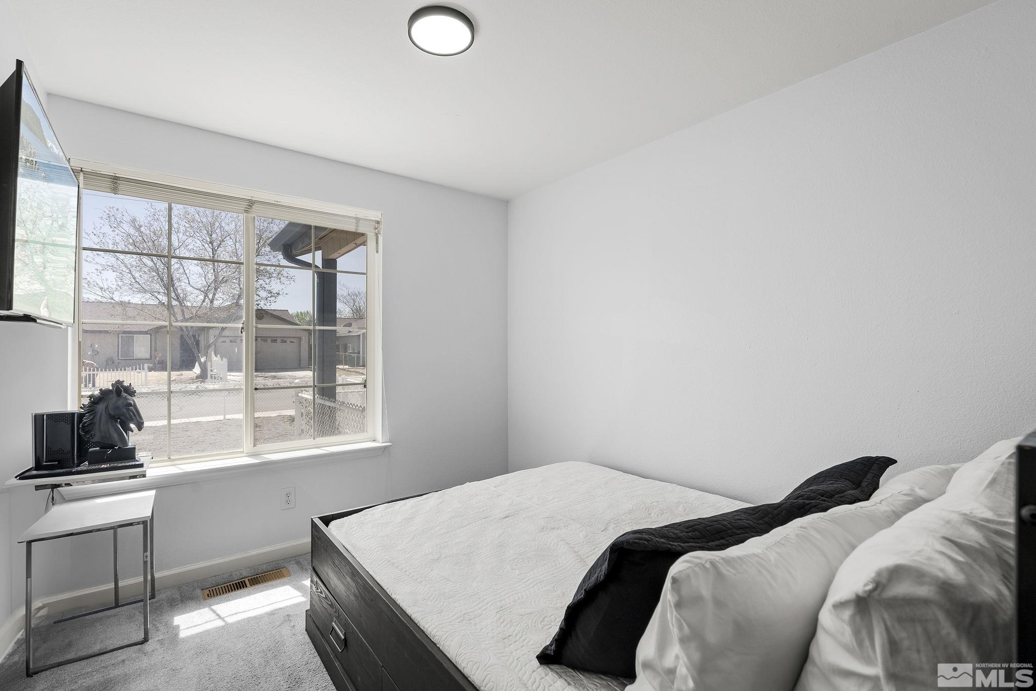 940 Atrium Road Fernley, NV 89408 - Photo 16 of 20 a bedroom with a bed and a window with chair