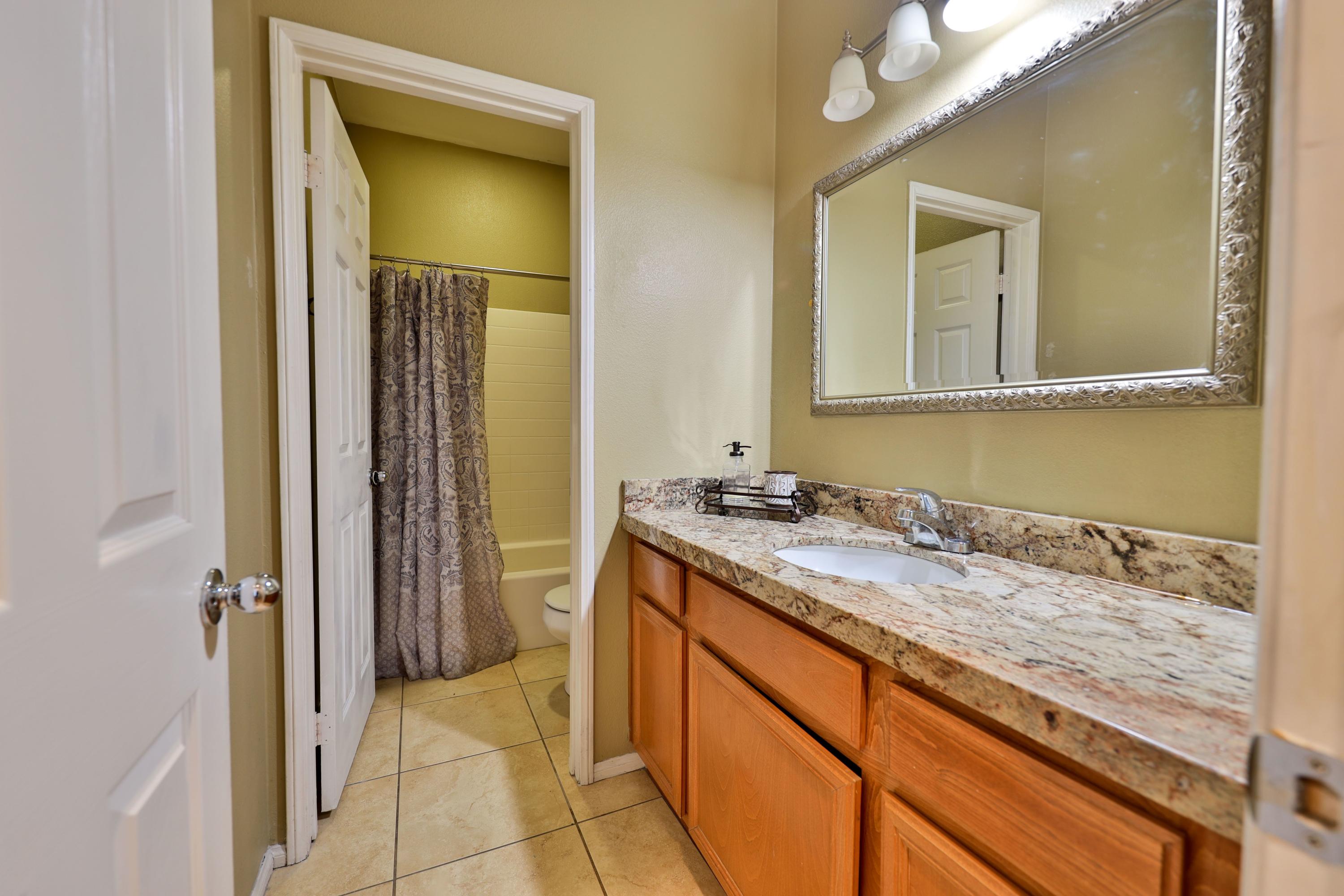 82834 Randsburg Lane Indio, CA 92203 - Photo 11 of 18 a bathroom with a granite countertop sink and a mirror