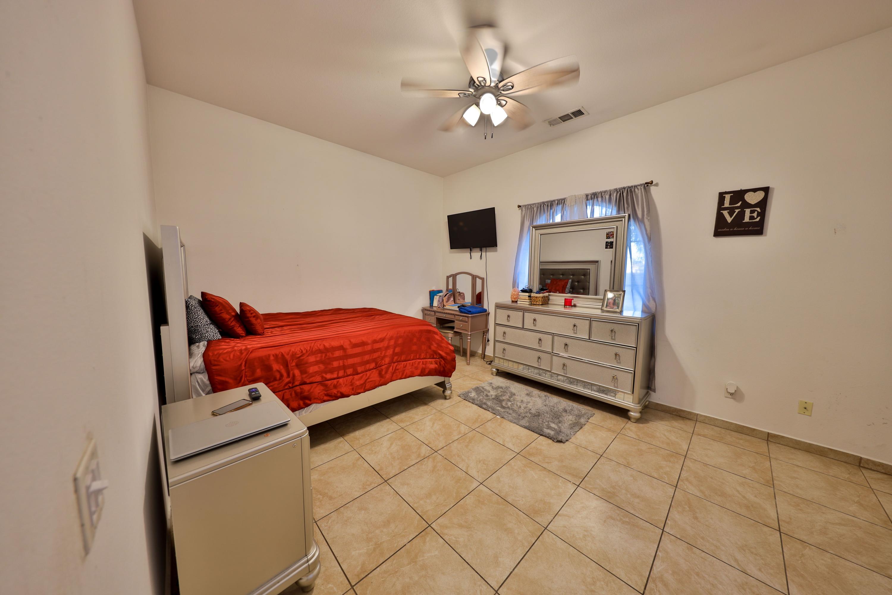 82834 Randsburg Lane Indio, CA 92203 - Photo 13 of 18 a bedroom with a bed and a chandelier