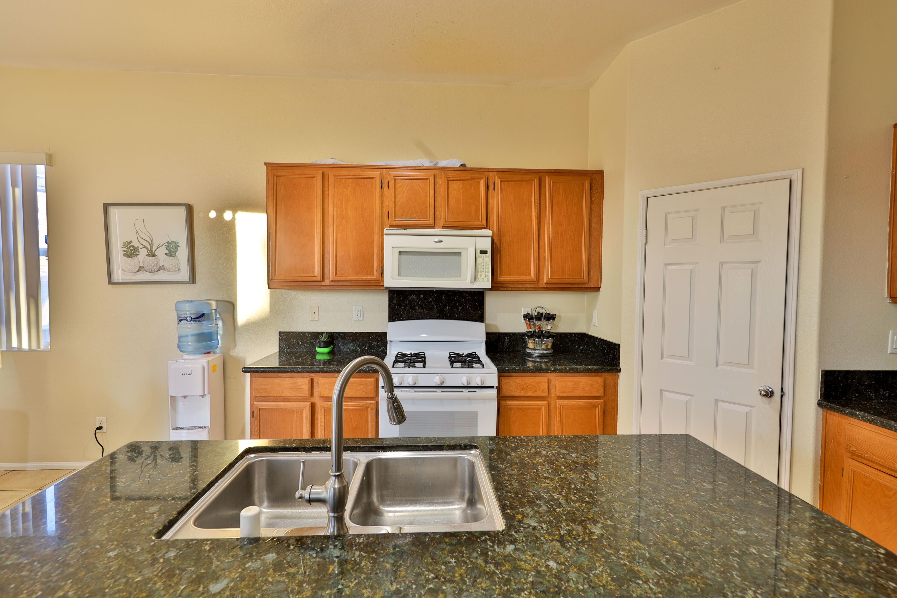 82834 Randsburg Lane Indio, CA 92203 - Photo 3 of 18 a kitchen with a sink a stove and a microwave
