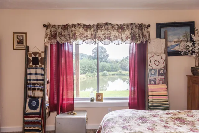a view of a town with large trees and barn in the background