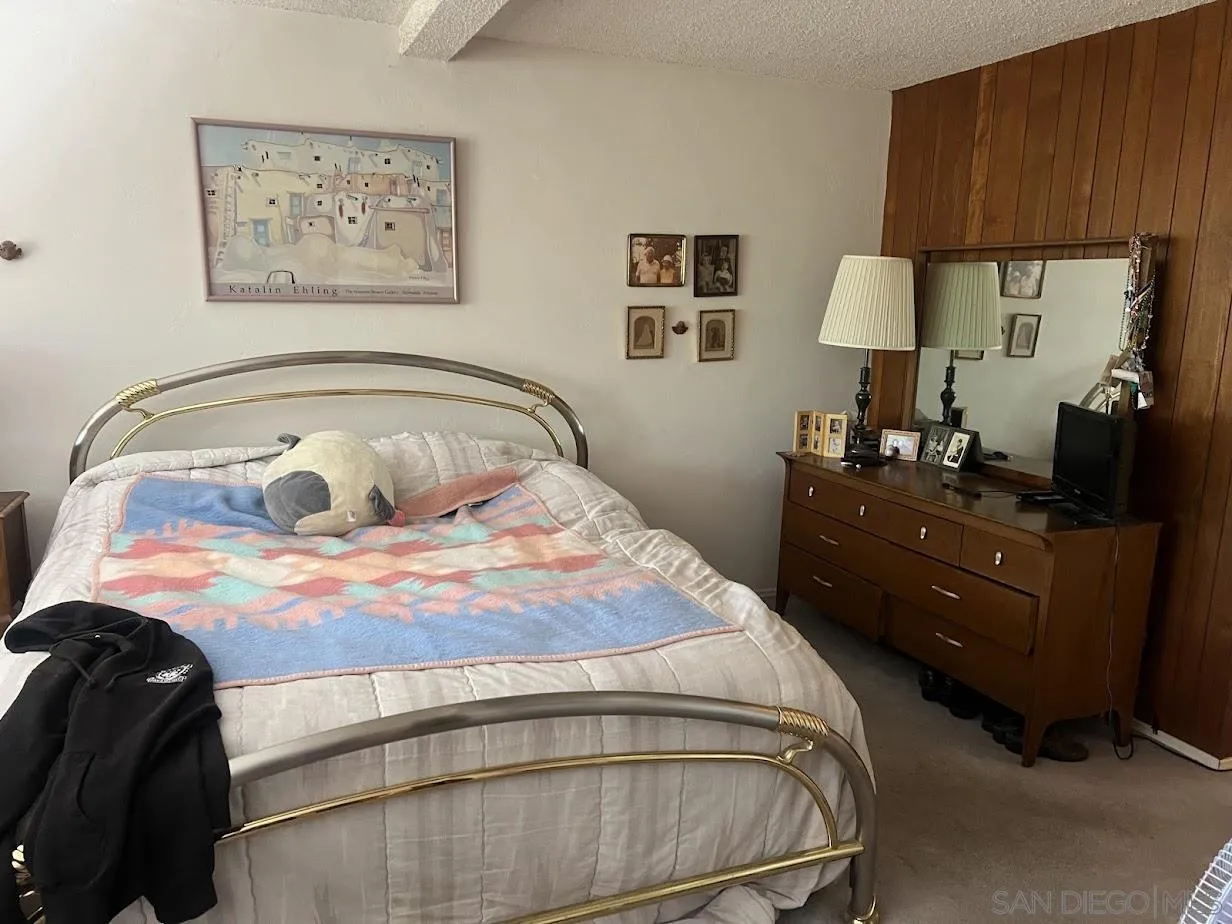 2630 Torrey Pines Road, Unit E21 La Jolla, CA 92037 - Photo 15 of 24 a bedroom with a bed and a lamp on dresser