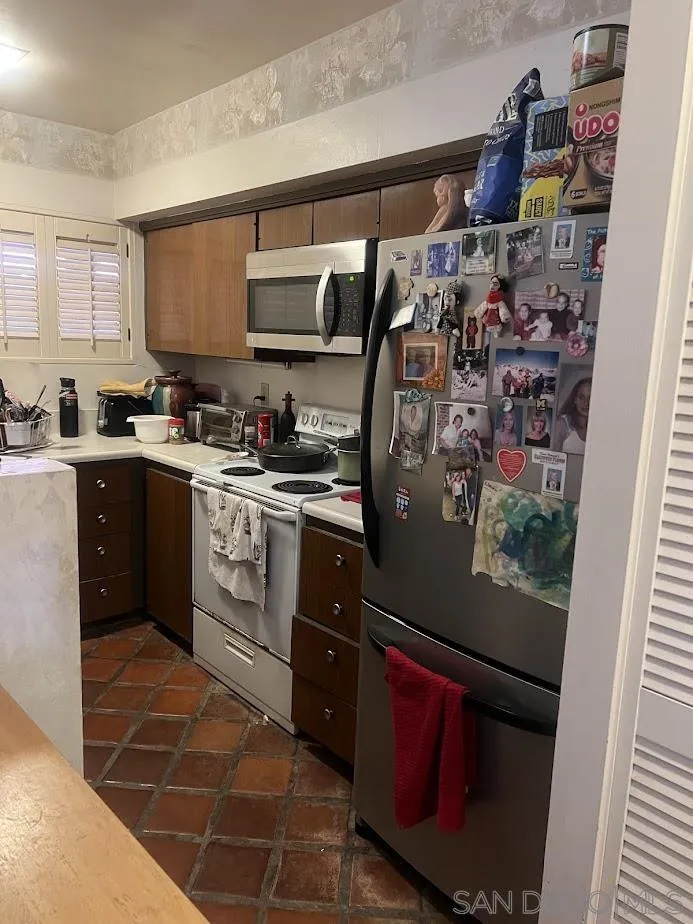 2630 Torrey Pines Road, Unit E21 La Jolla, CA 92037 - Photo 2 of 24 a kitchen with stainless steel appliances granite countertop a refrigerator and a sink