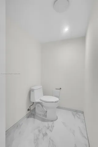 a white toilet sitting next to a white cabinet