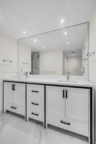 a bathroom with a sink a vanity a mirror and a bathtub