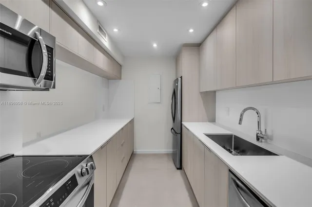 a kitchen with a sink and stainless steel appliances