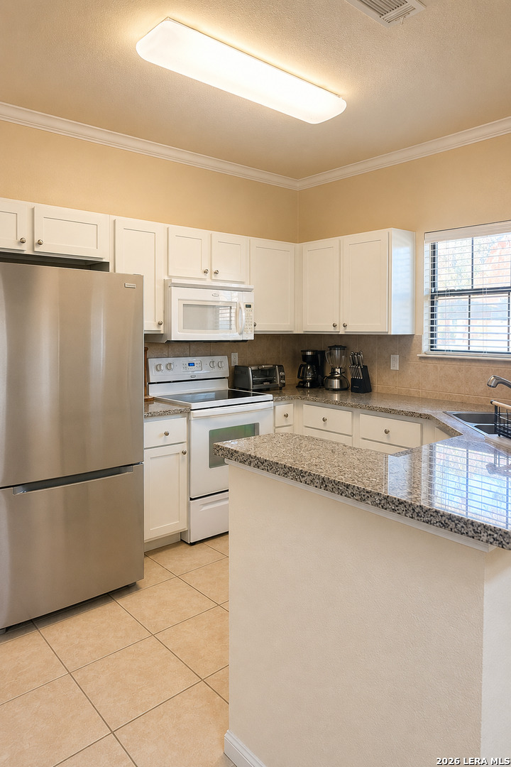 6160 Eckhert Road, Unit 804 San Antonio, TX 78240 - Photo 10 of 38 a kitchen with granite countertop a refrigerator and a sink