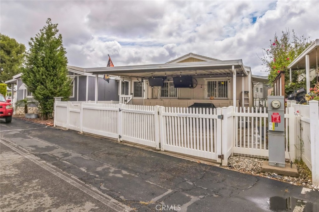 8221 Ilex Street, Unit 10 Rancho Cucamonga, CA 92335 - Photo 10 of 27 a view of a white house with large windows and a small yard