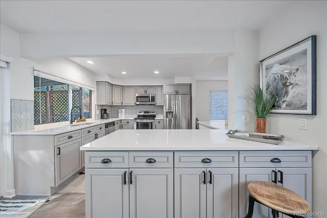 a kitchen with a table chairs refrigerator and cabinets