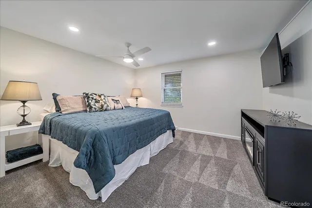 a spacious bedroom with a bed and a flat screen tv